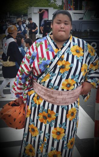 Le rikishi Sanzo, un Japonais de 22 ans, fait partie des grands espoirs de la discipline. Pour l’instant mal classé, il ne roule pas sur l’or et a débarqué au Ryogoku en métro, au milieu des supporters.